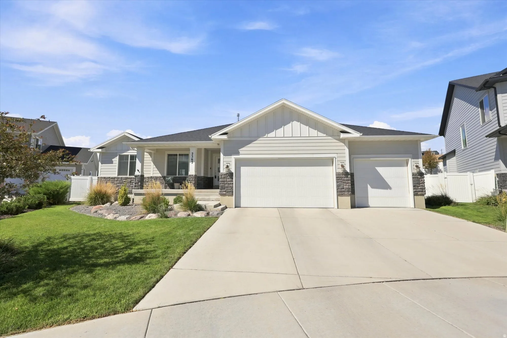 Ranch-style exterior with light gray siding, a stone facade, and a covered porch