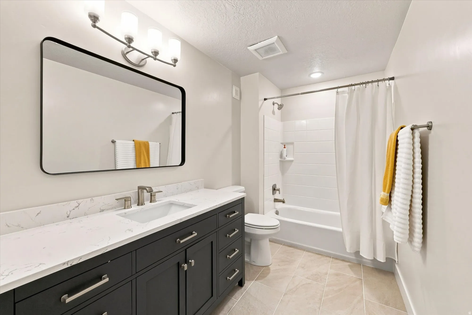 White rectangular undermount sink with a brushed nickel faucet, large vanity mirror, white subway tile shower surround, and beige tile flooring