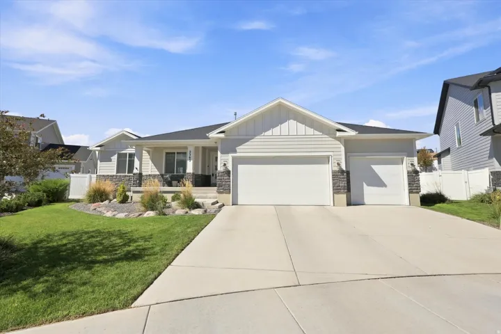 Ranch-style exterior with light gray siding, a stone facade, and a covered porch