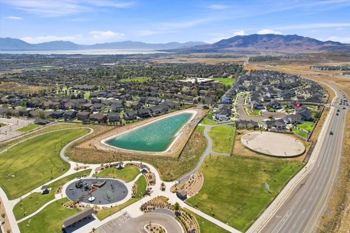 Expansive residential area featuring a prominent lake, a large park with playground equipment, and a sports field
