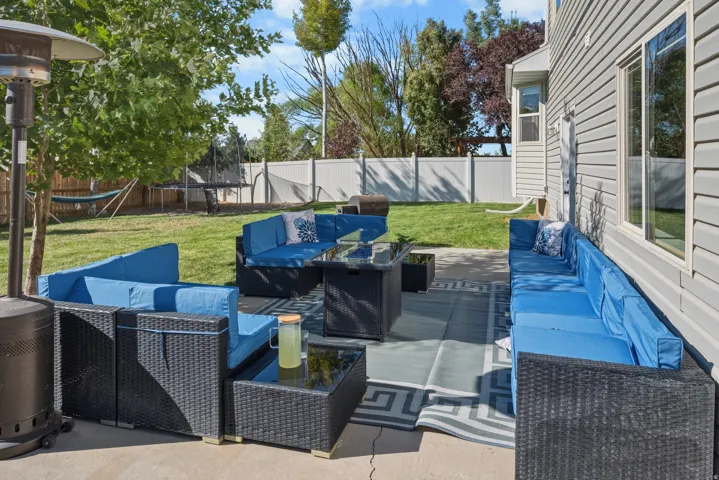 Expansive concrete patio with a full fence surround, and mature landscaping