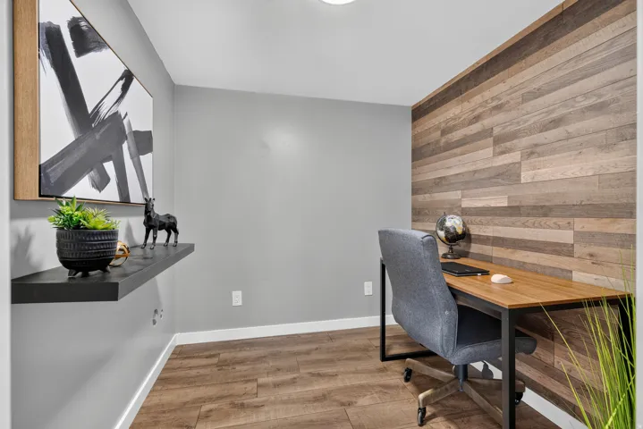 Wood-finish flooring, accent wall with horizontal wood paneling, recessed lighting, and a floating wall shelf