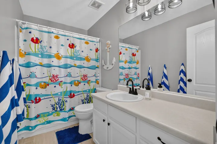 Single vanity with white cabinetry, integrated sink, and black fixtures