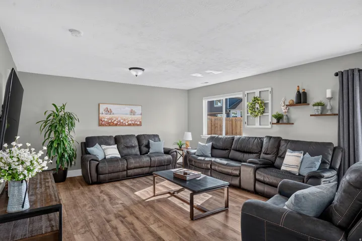 Wood-finish flooring throughout, light gray wall color, multiple windows providing natural illumination, ceiling-mounted lighting fixtures