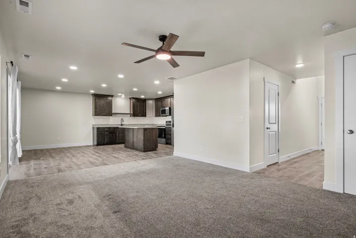 Kitchen area with wood-finish flooring, dark wood cabinetry, and a central island