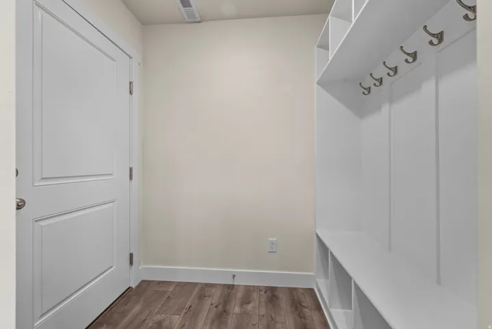 Built-in storage bench with cubbies, upper shelving, and wall-mounted hooks