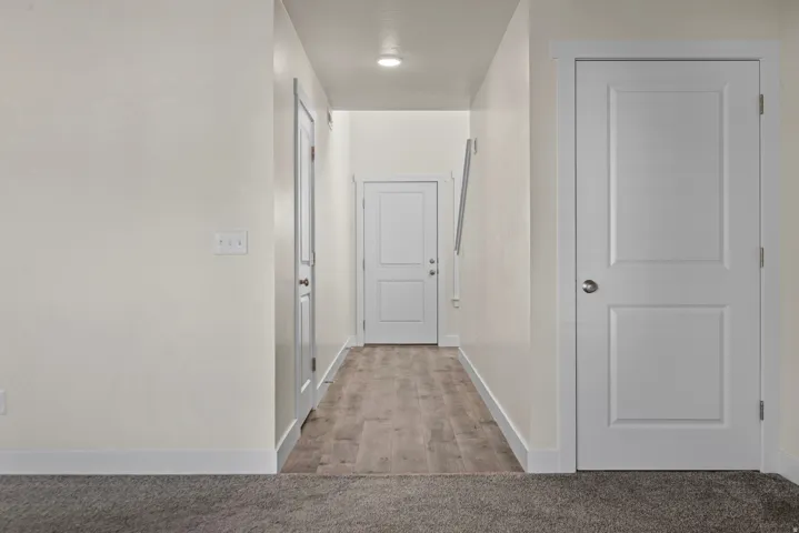Hallway with wood-finish flooring, recessed lighting, and white paneled doors