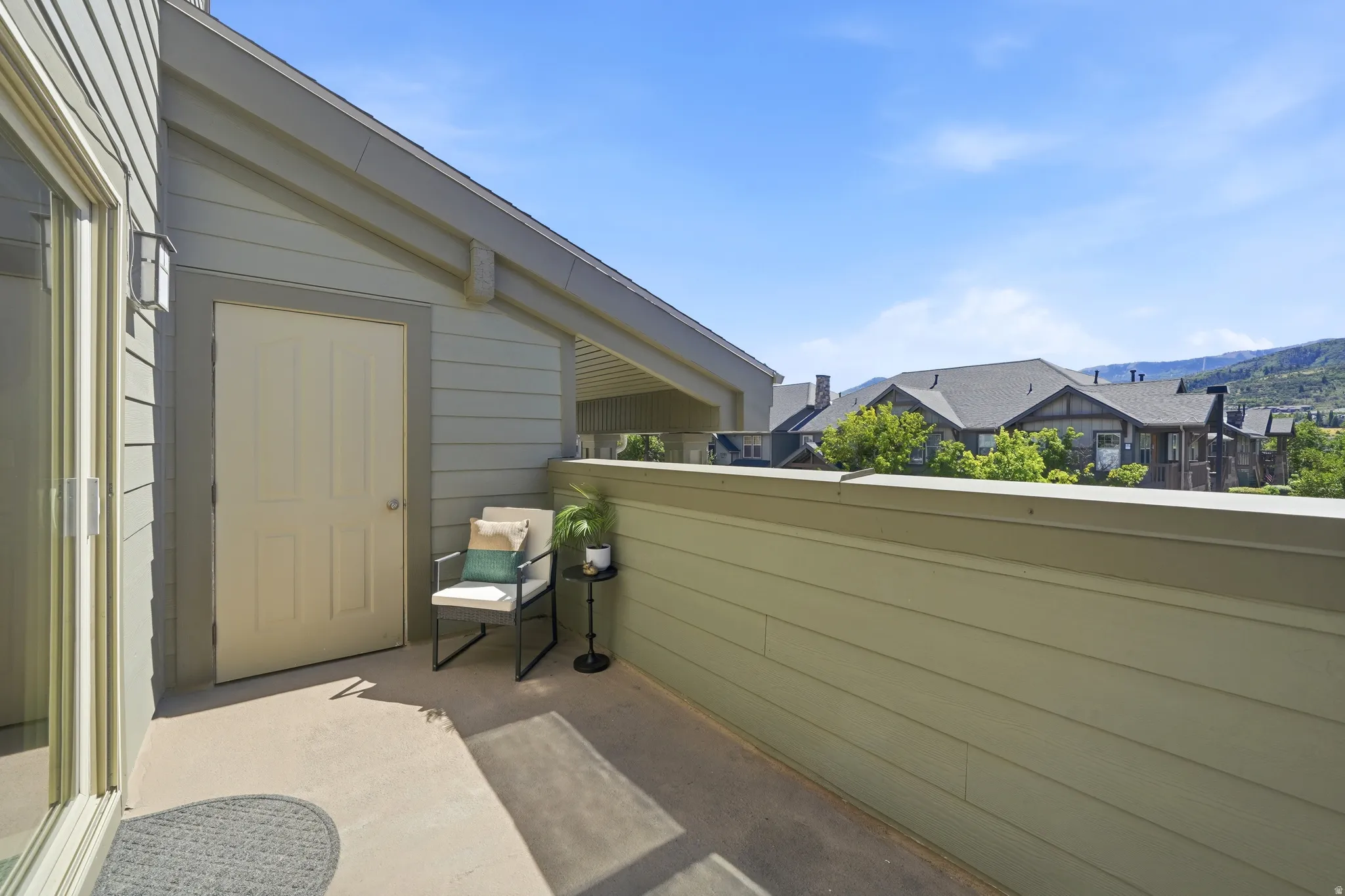 Private balcony featuring exterior siding, outdoor lighting, and mountain views