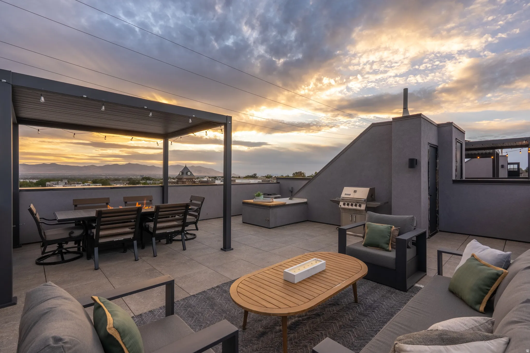 Rooftop deck featuring a metal pergola, paver flooring, built-in outdoor kitchen, and a stainless steel grill