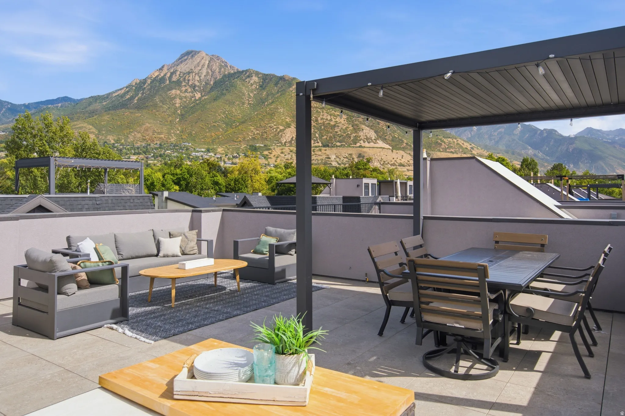 Rooftop patio featuring a slatted pergola, durable outdoor flooring, and a low privacy wall