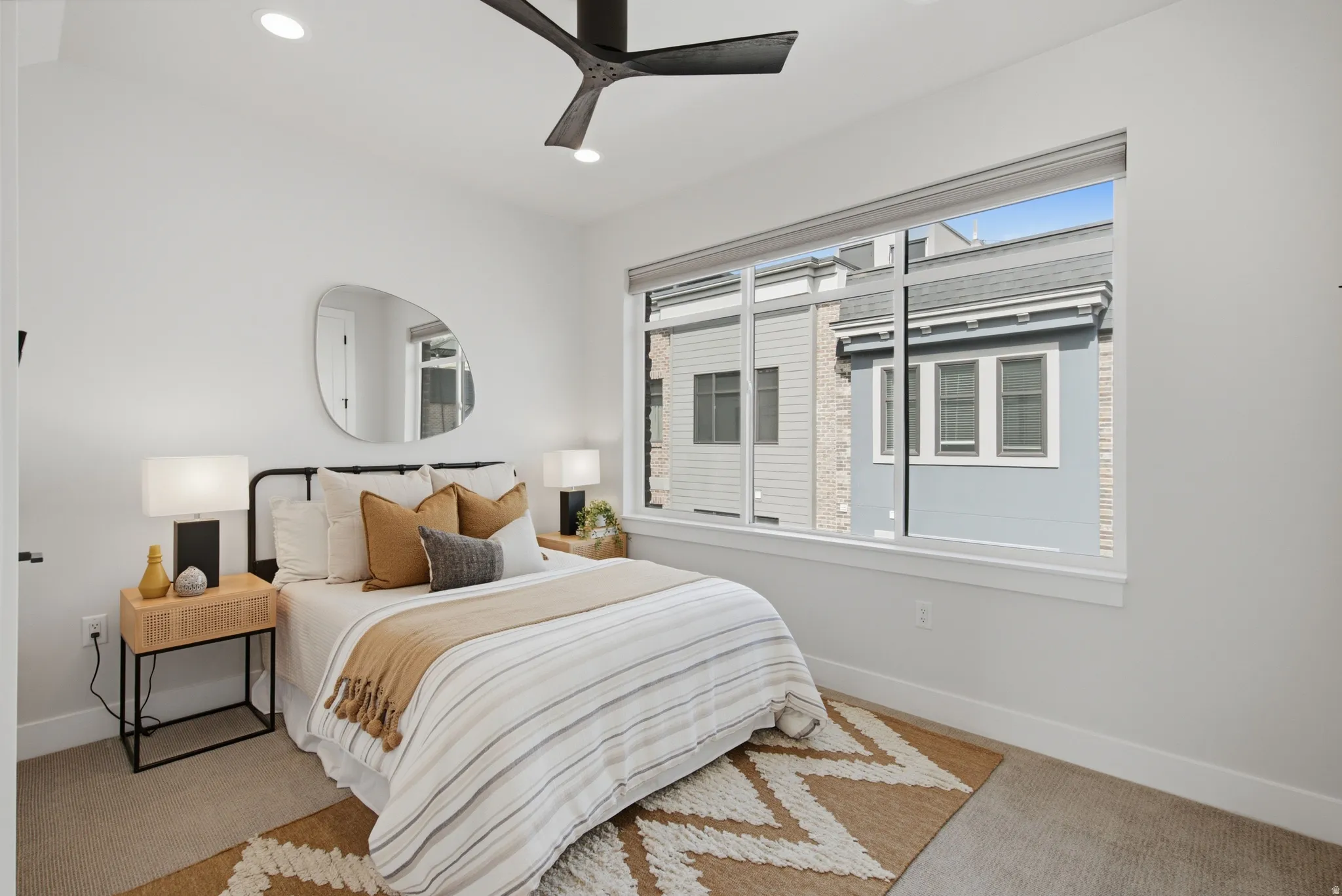 Recessed lighting, ceiling fan, expansive window, neutral wall paint, and carpeting