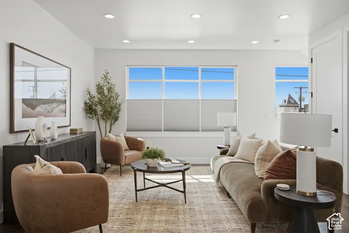 Recessed lighting, wood-finish flooring, multiple windows with blinds, and white interior doors with dark hardware
