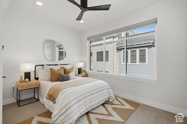 Recessed lighting, ceiling fan, expansive window, neutral wall paint, and carpeting