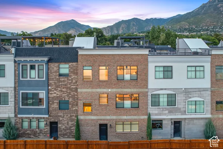 Townhomes featuring brick and stucco exteriors, varied window styles, and flat rooftops with railings