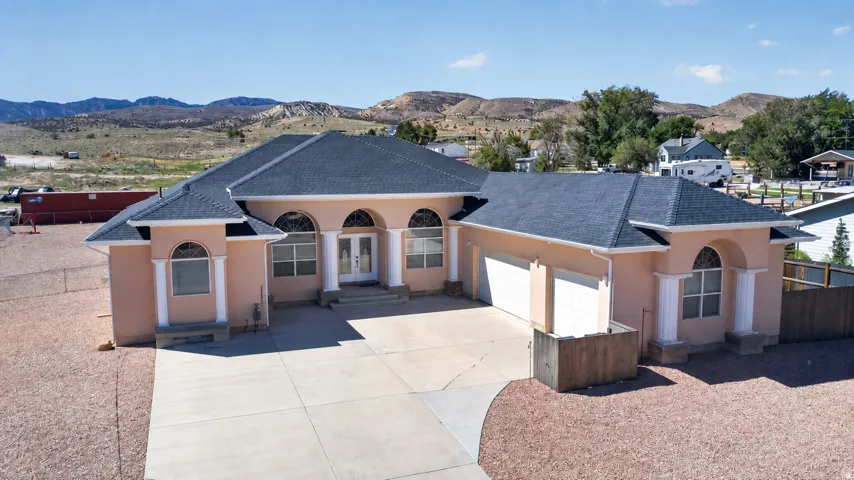 Stucco exterior with arched windows, prominent entry columns, and an integrated two-car garage