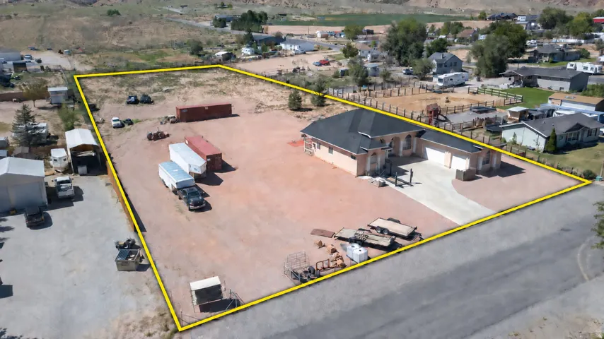 Expansive lot featuring a single-story residence with a two-car garage, paved driveway, and substantial undeveloped land