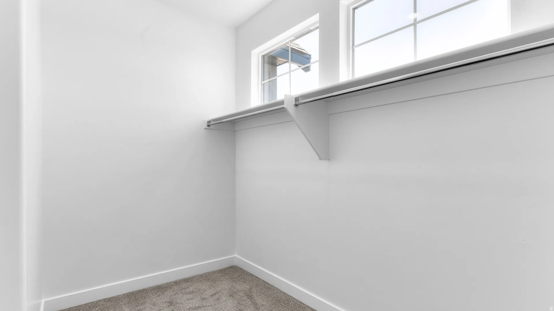 Built-in shelving with hanging rod, dual pane windows, and carpeting