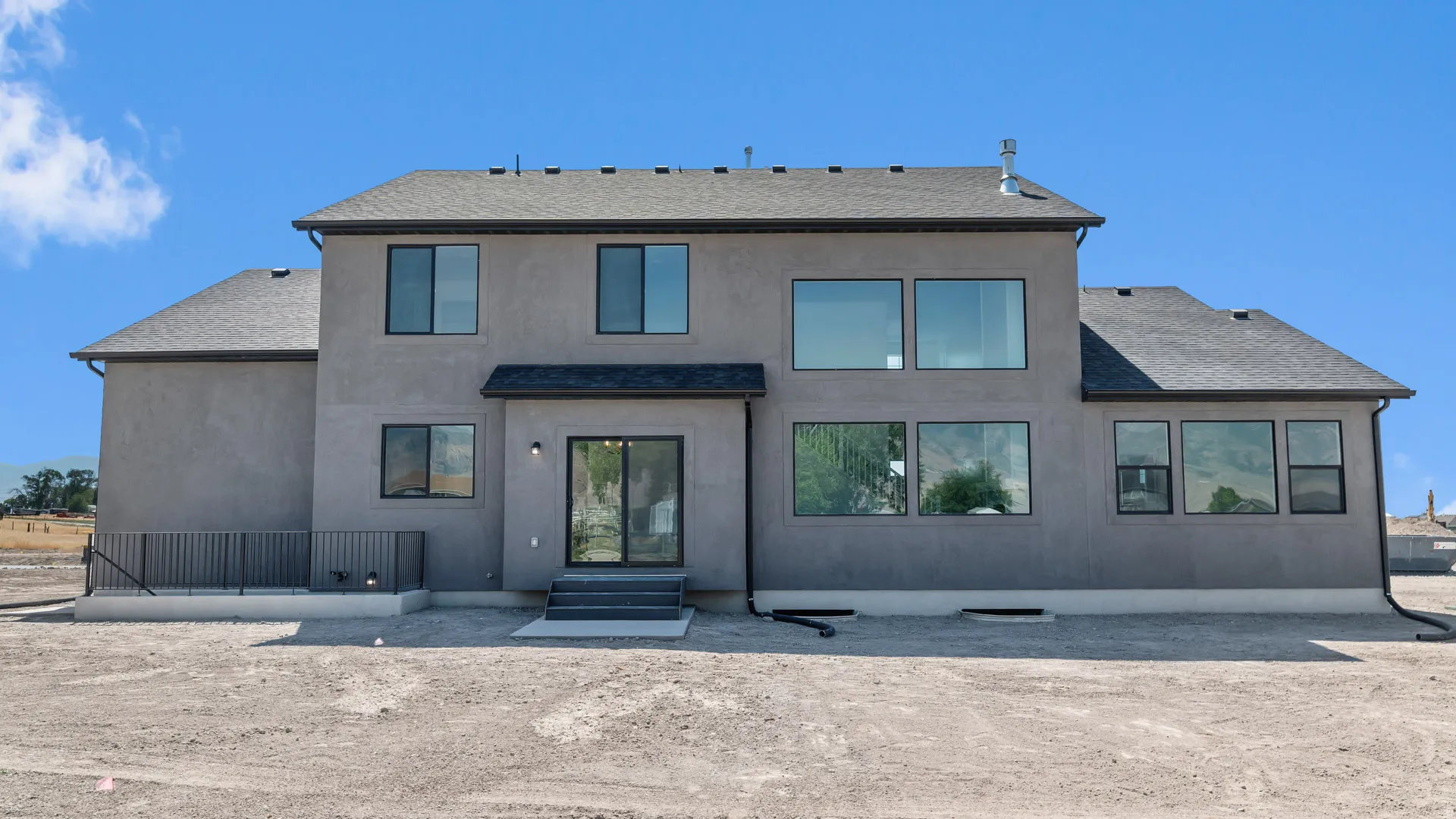 Contemporary stucco exterior with a dark shingle roof