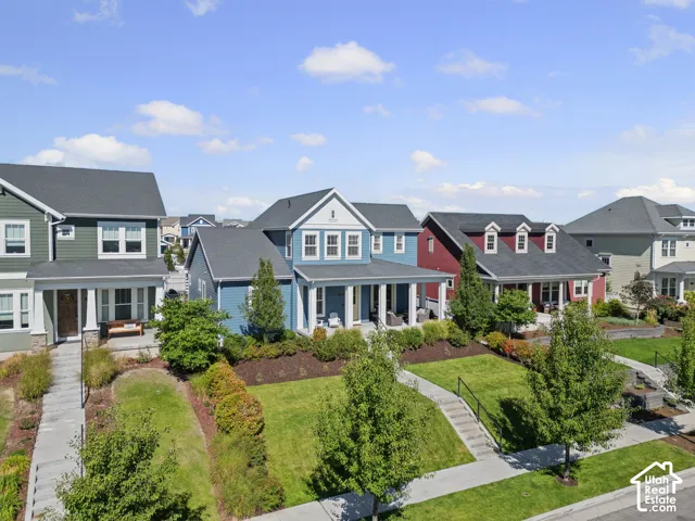 Siding exterior, covered porch, dormer windows, landscaped front yard, and concrete walkways