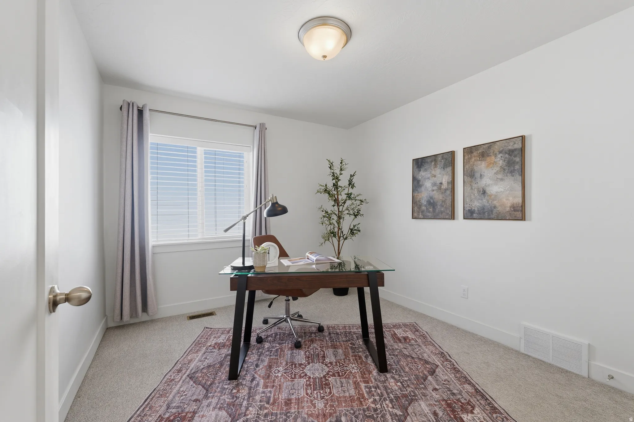 Neutral color palette with white walls, carpeted flooring, and a single window with blinds