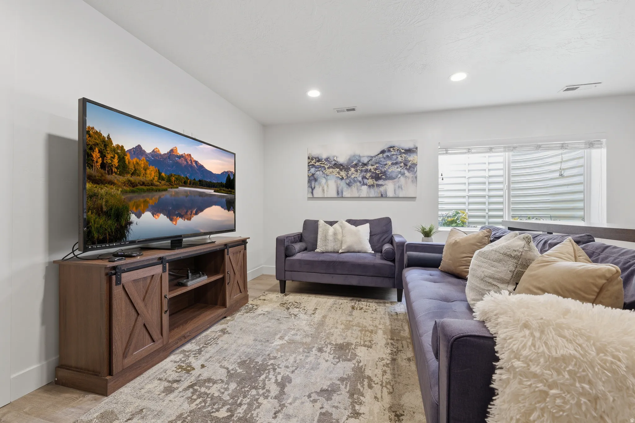 Recessed lighting, light-toned walls, and wood-finish flooring