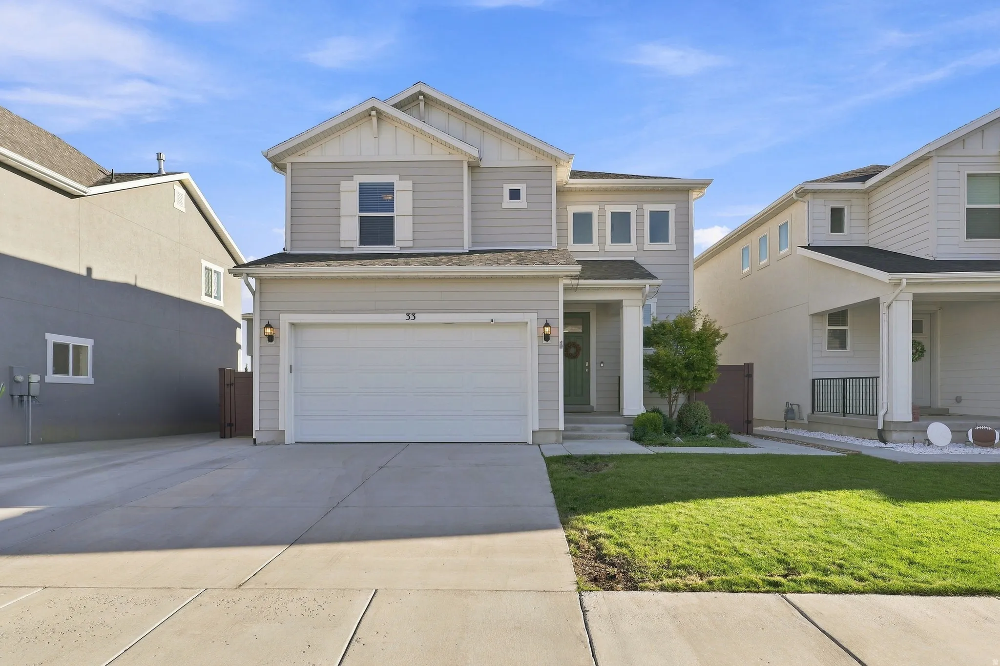 Contemporary two-story residence with a light gray facade, white trim, and an attached two-car garage