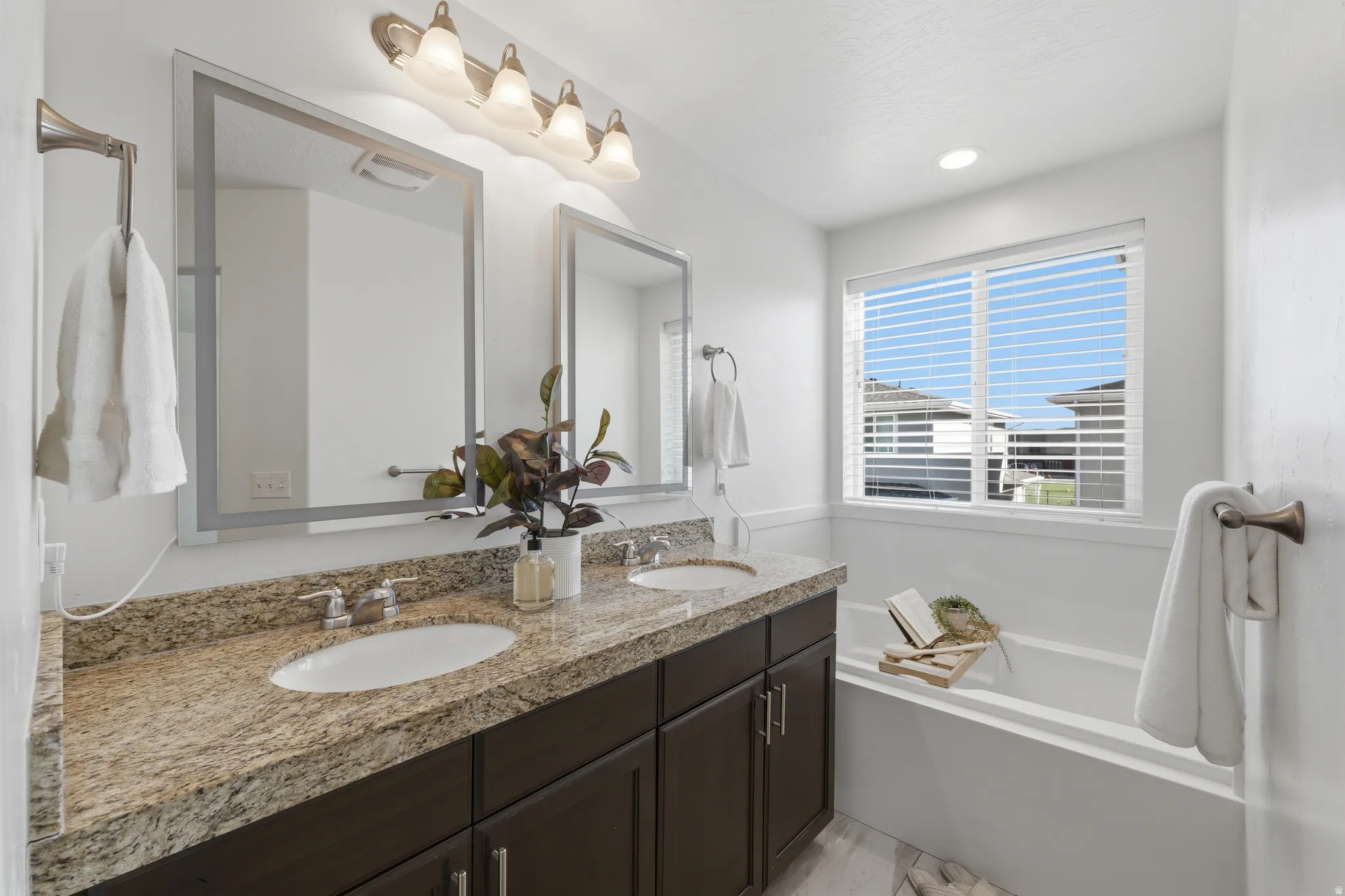Double vanity featuring undermount sinks and granite-style countertops