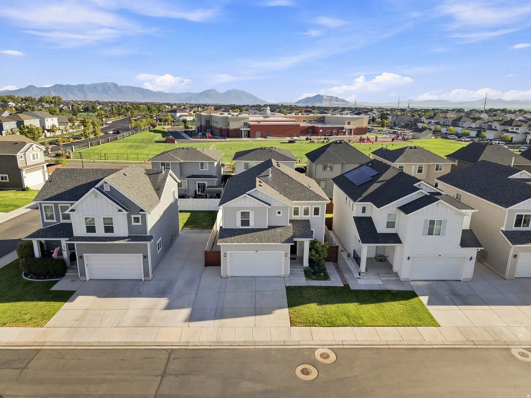 The property features a two-story residence with an attached garage, a paved driveway, and a manicured front lawn