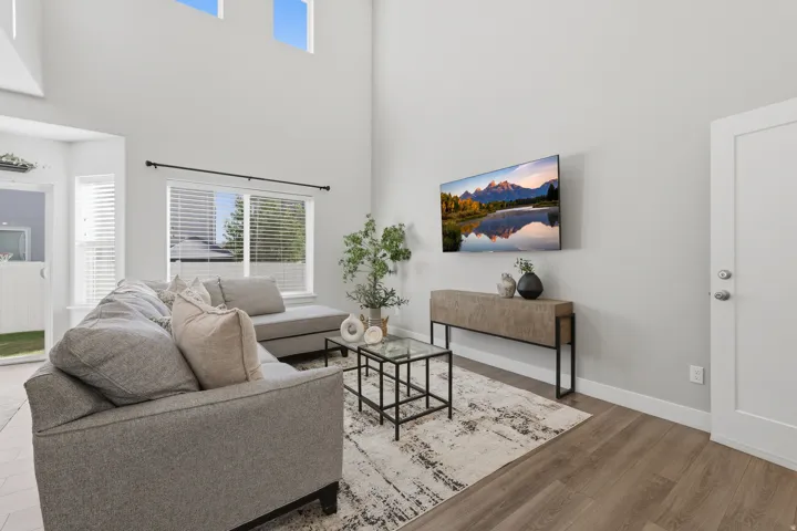 Vaulted ceilings, expansive windows, wood-finish flooring, and a contemporary light color palette