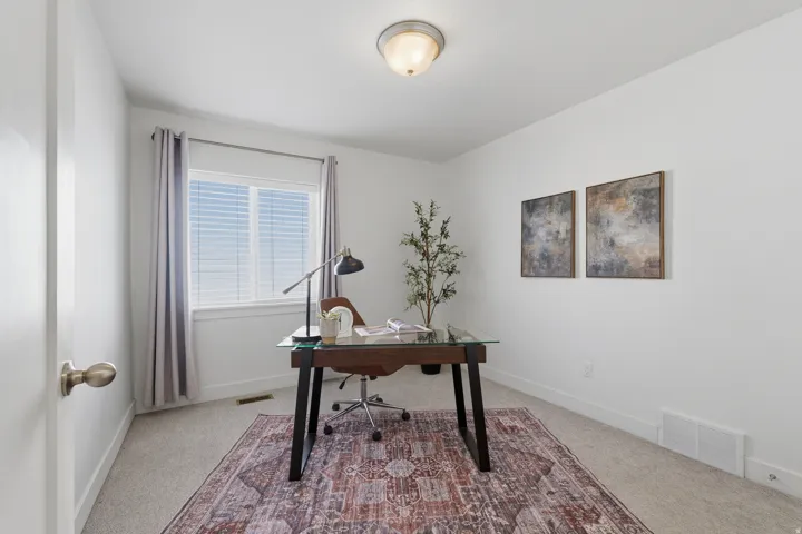 Neutral color palette with white walls, carpeted flooring, and a single window with blinds