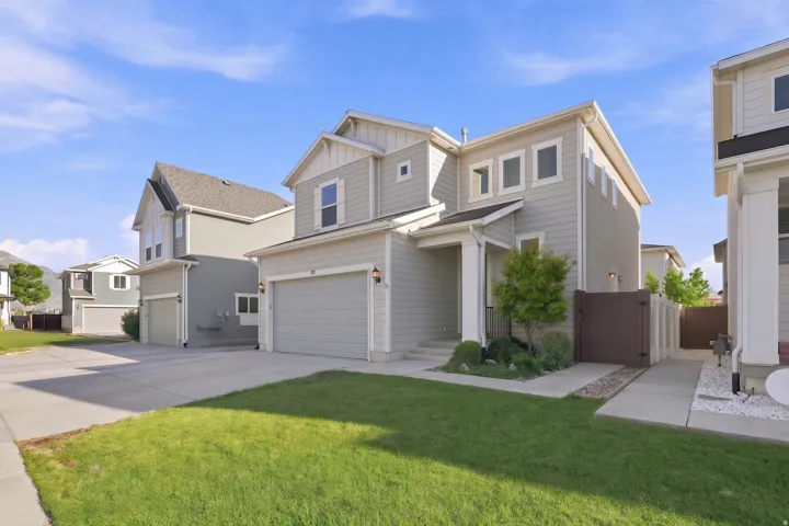 Light grey siding exterior with white trim and gables, a two-car garage, and a covered entry