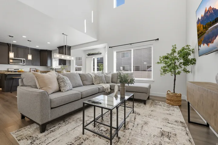 Vaulted ceilings with high windows, wood-finish flooring, dark cabinetry, and recessed lighting