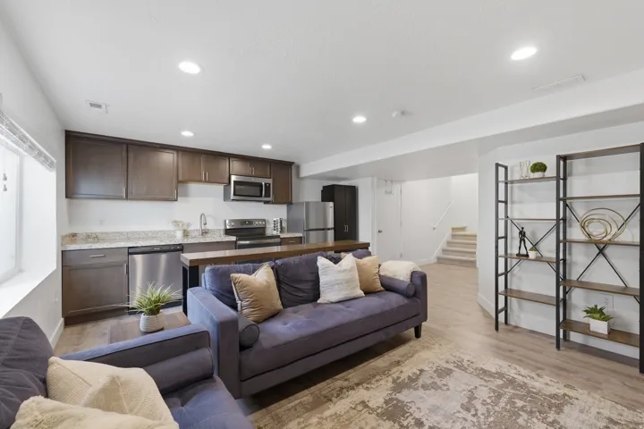 Kitchenette featuring dark wood-finish cabinetry, stainless steel appliances, and a granite-style countertop