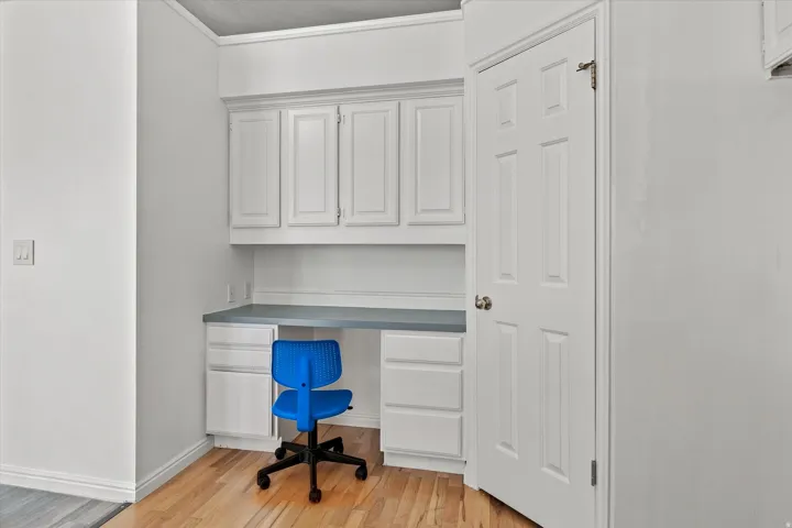 Built-in desk with upper cabinetry, lower drawers, and a light-toned countertop