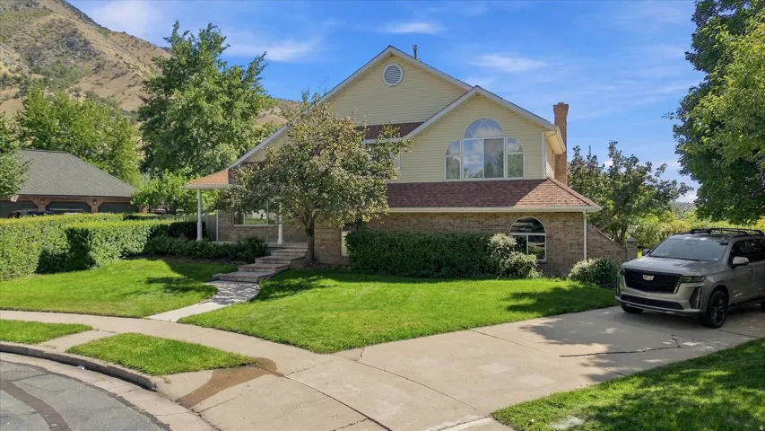 Two-story property with a light-colored siding, partial brick exterior, and an arched window