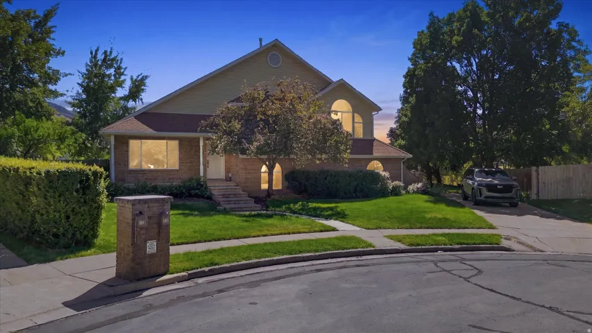 Brick exterior with a peaked roof, arched window, and mature landscaping