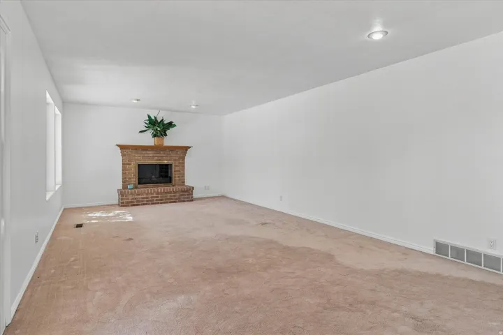 Living area featuring a brick fireplace with a wood mantle, recessed lighting, and multiple windows