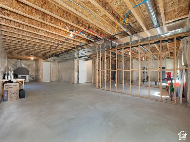 Unfinished basement space featuring exposed wood framing, concrete flooring, and visible ductwork