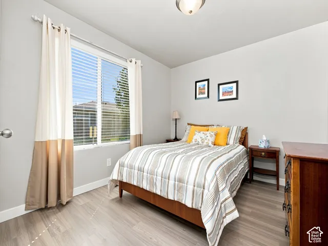 Neutral gray walls, a window with horizontal blinds, and wood-finish flooring