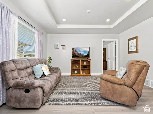 Recessed lighting, tray ceiling, and wood-finish flooring