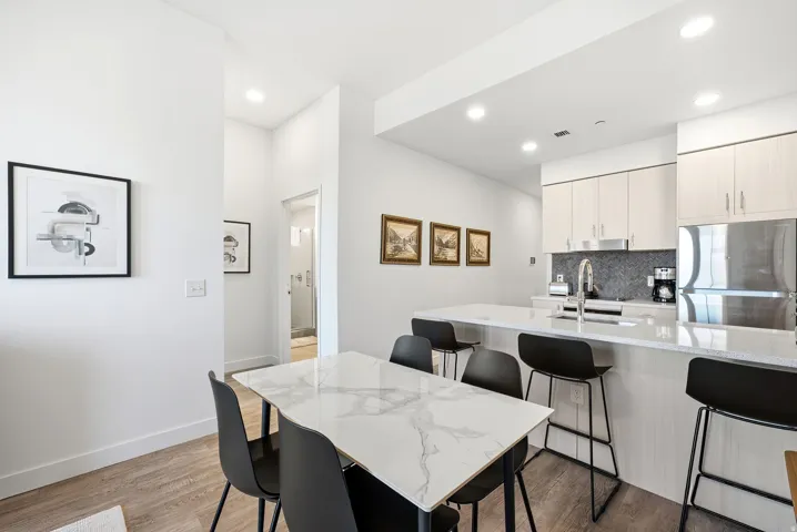 Open-concept kitchen with light-finish cabinetry, stainless steel appliances, and a light-toned countertop