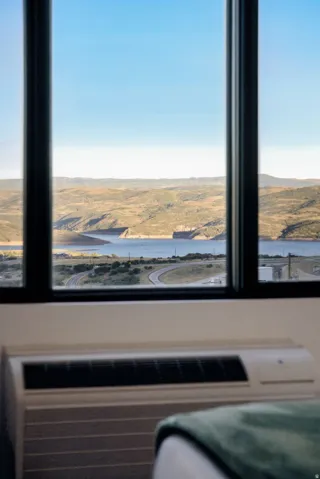 Framed windows overlooking a body of water and distant terrain