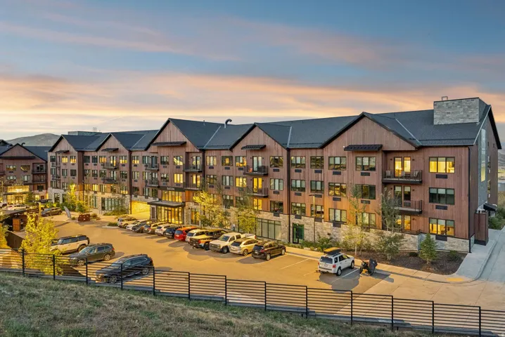 Multi-story building featuring wood-finish siding, stone accents, and multiple balconies