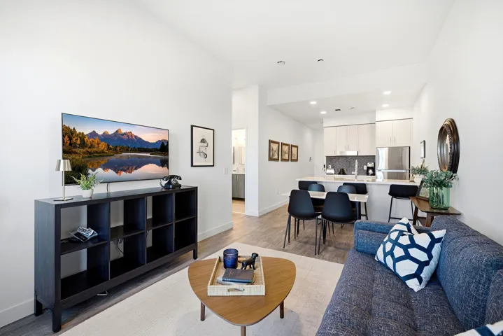 Open-concept living space with wood-finish flooring, white walls, and recessed lighting