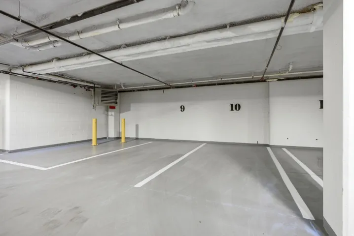 Designated parking space with painted floor markings and structural support poles
