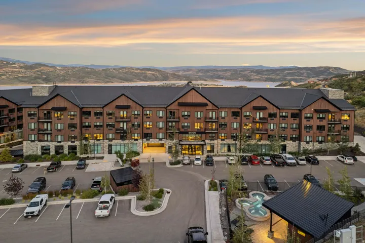 Multi-story building featuring a wood-finish facade, stone accents, and multiple balconies