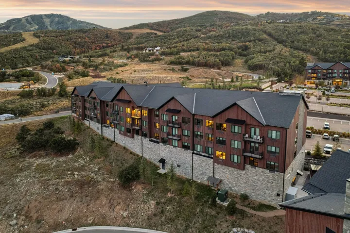 Multi-story residential structure featuring wood siding, stone accents, and multiple balconies