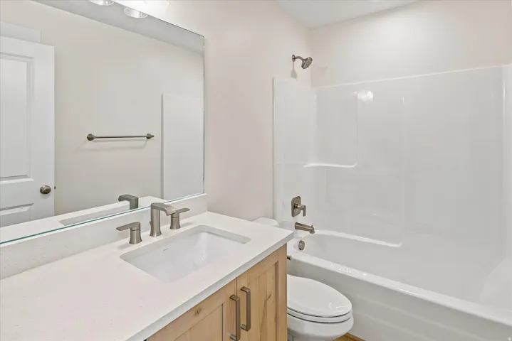 Vanity with a light-toned countertop, undermount sink, and brushed nickel fixtures