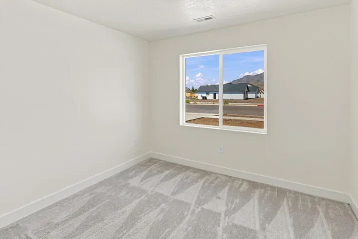Neutral wall finishes, light gray patterned carpeting, and white trim
