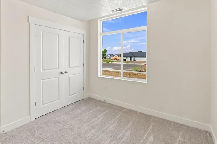 Wall-to-wall carpeting and a large window providing natural light